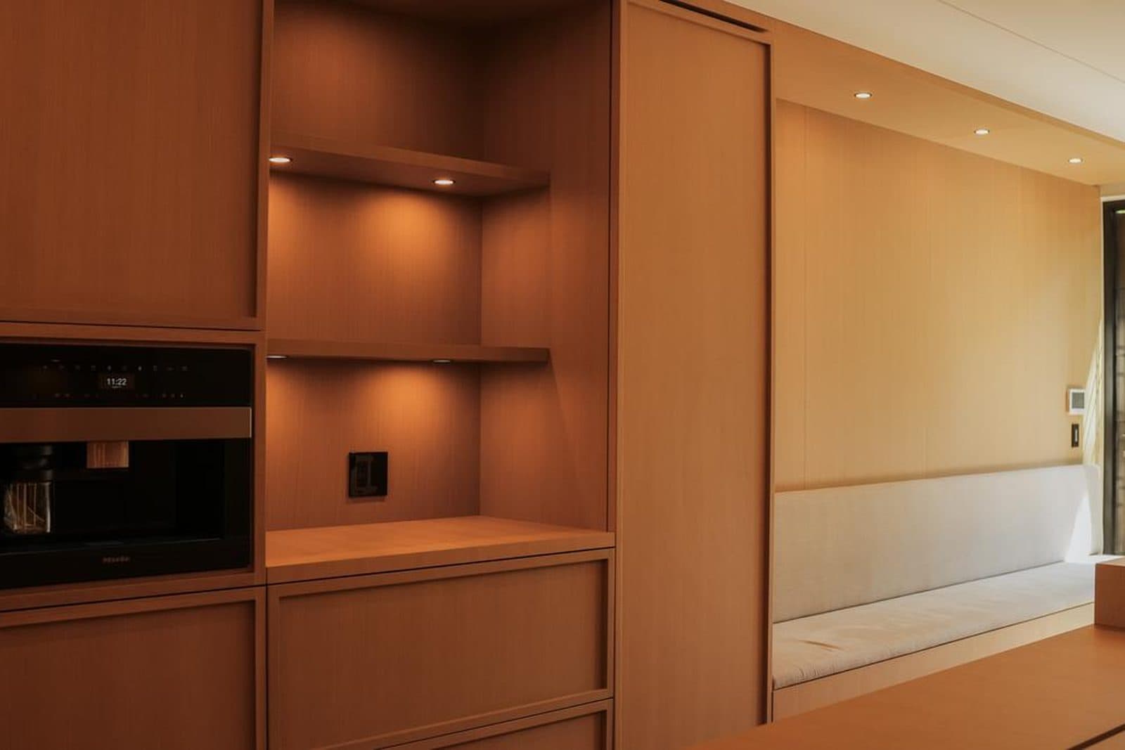 Built-in oak millwork wall with open shelving and an integrated coffee station