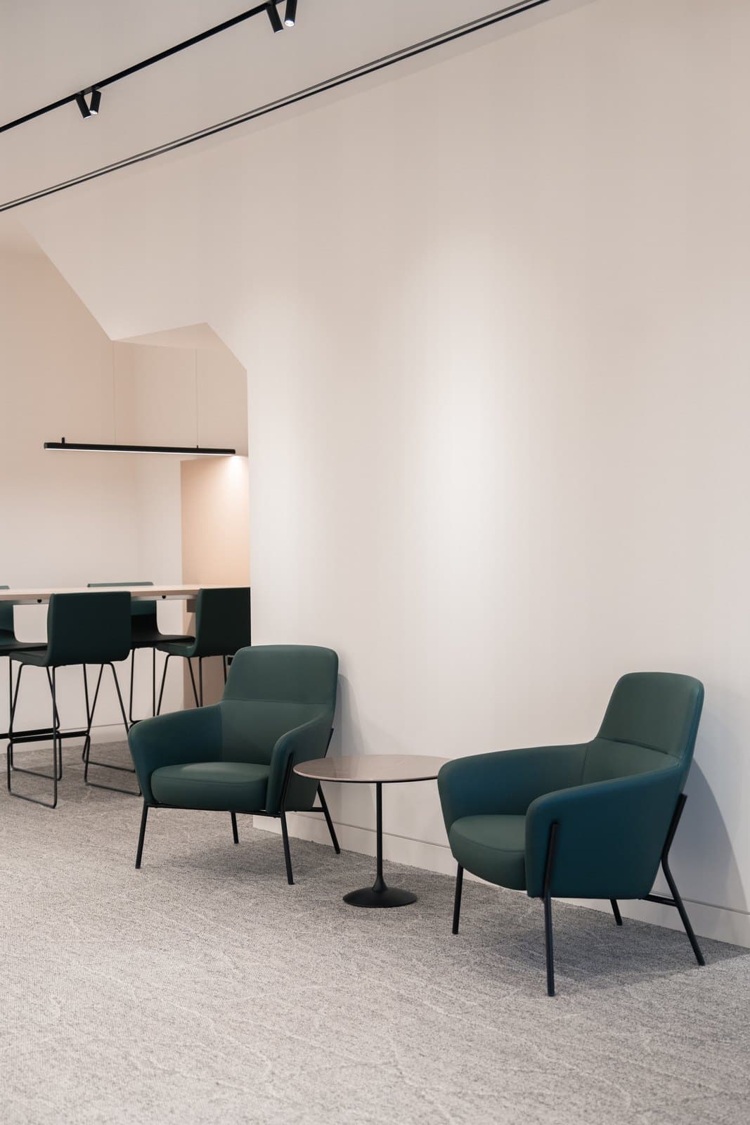 Lounge corner with upholstered chairs and a low table in a corporate fit out