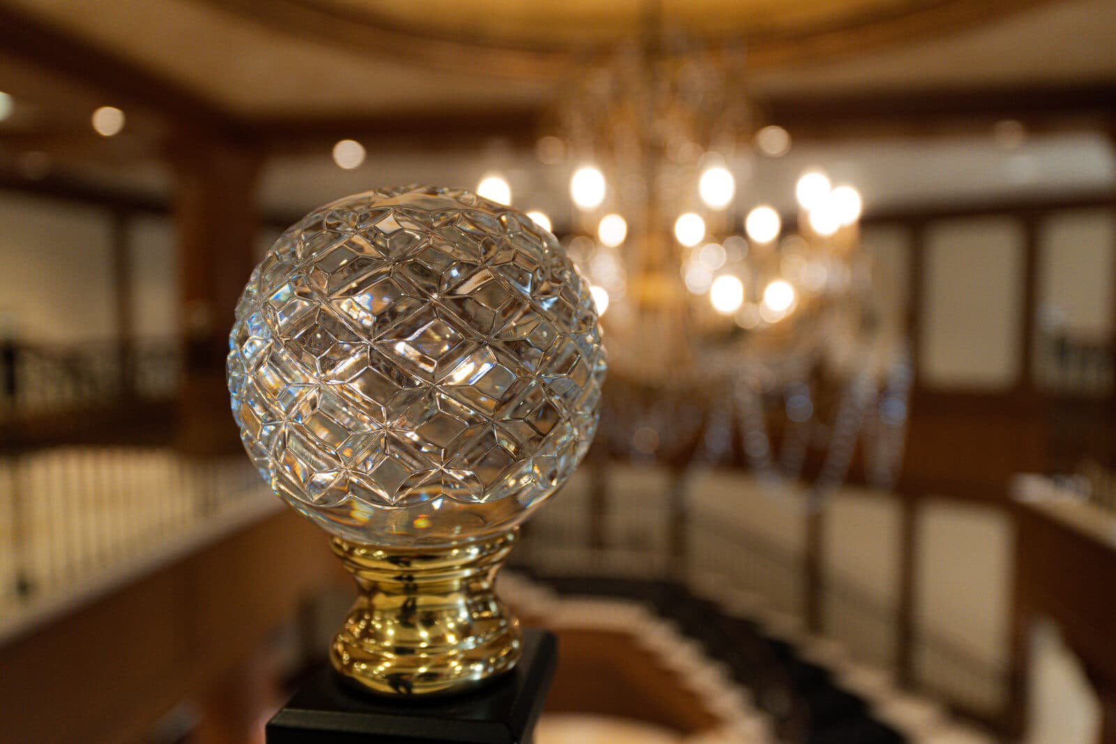 Hand set crystal finial at the base of a stair