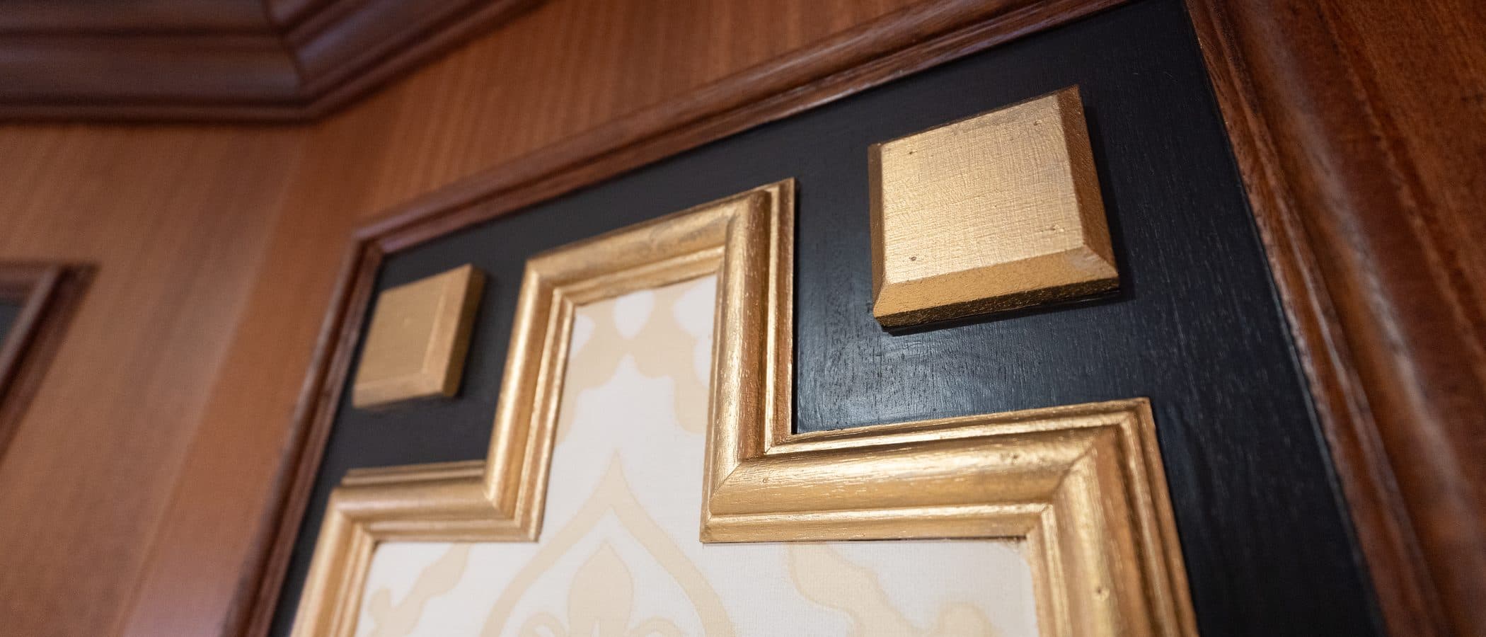 Gilt corner detail where mahogany trim meets black lacquer