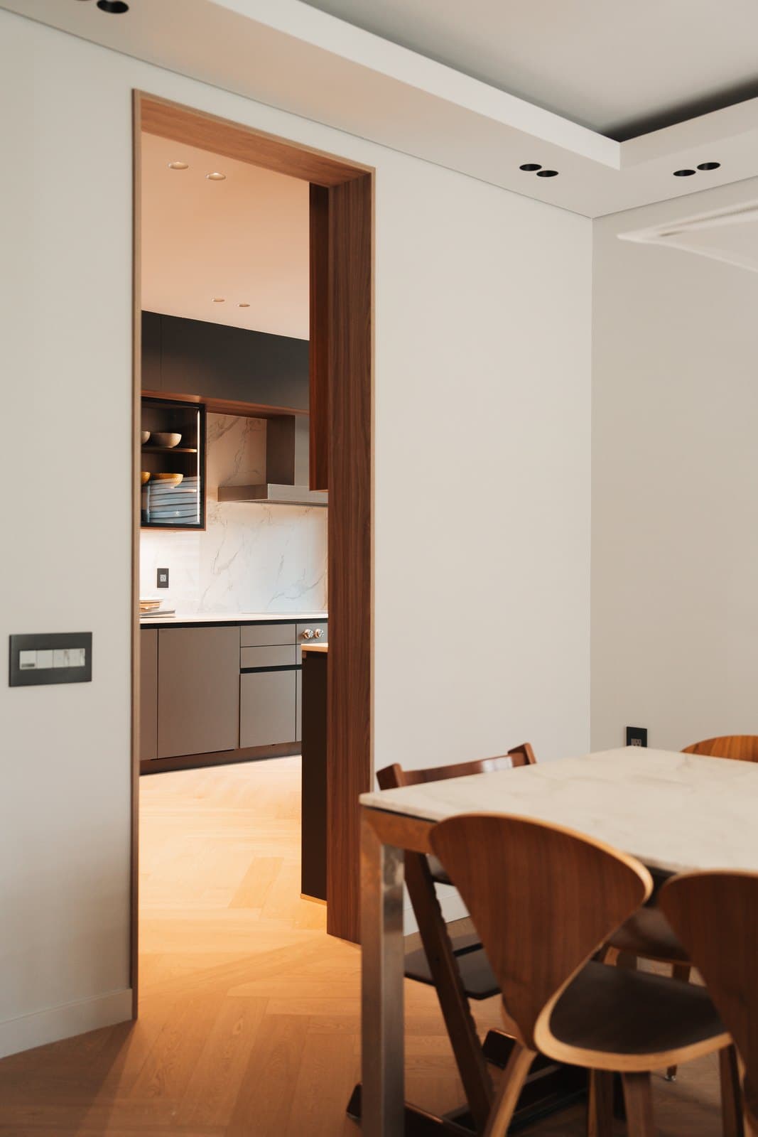 View through a walnut cased opening into the dark kitchen