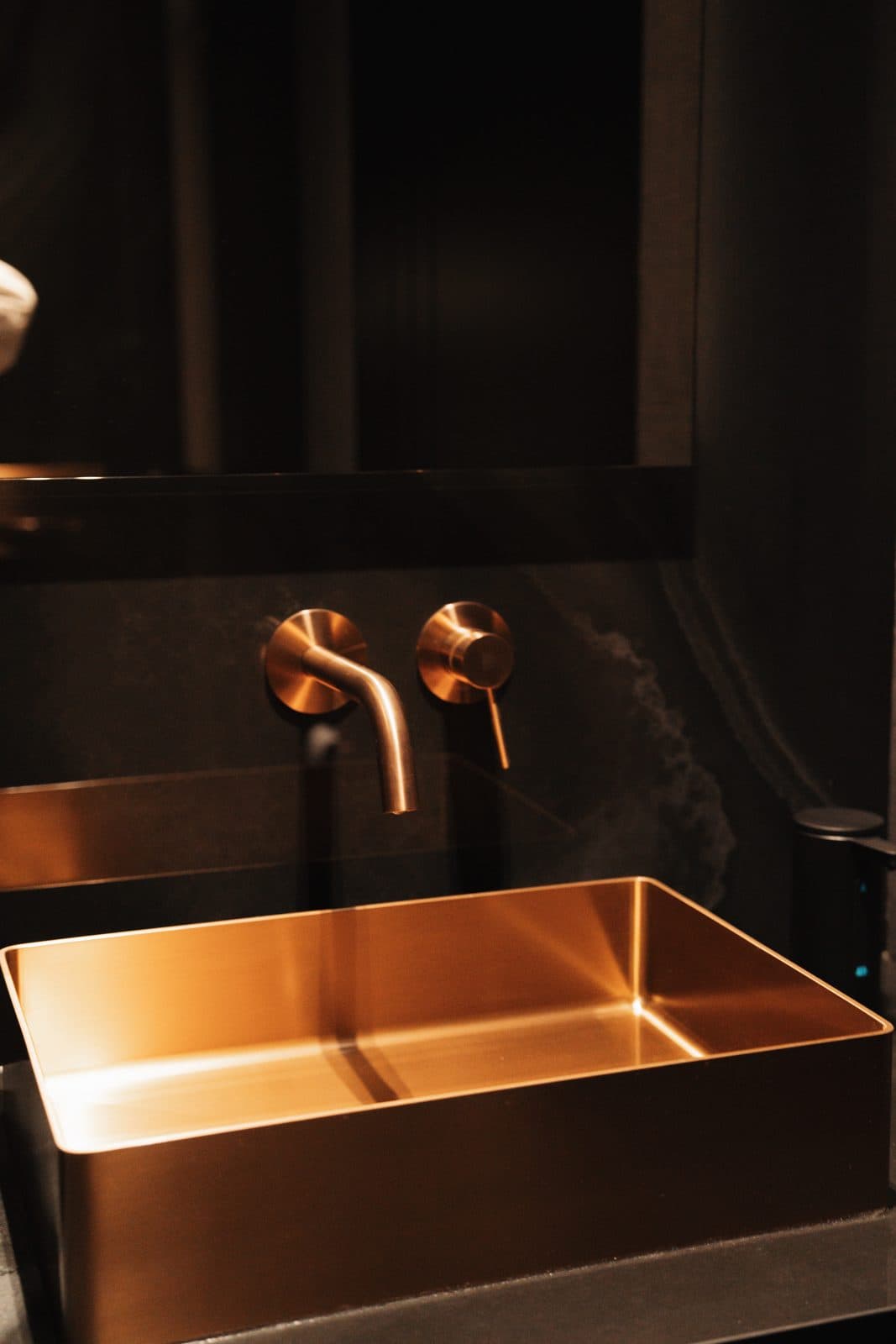 Bronze vessel basin lit from above against dark stone