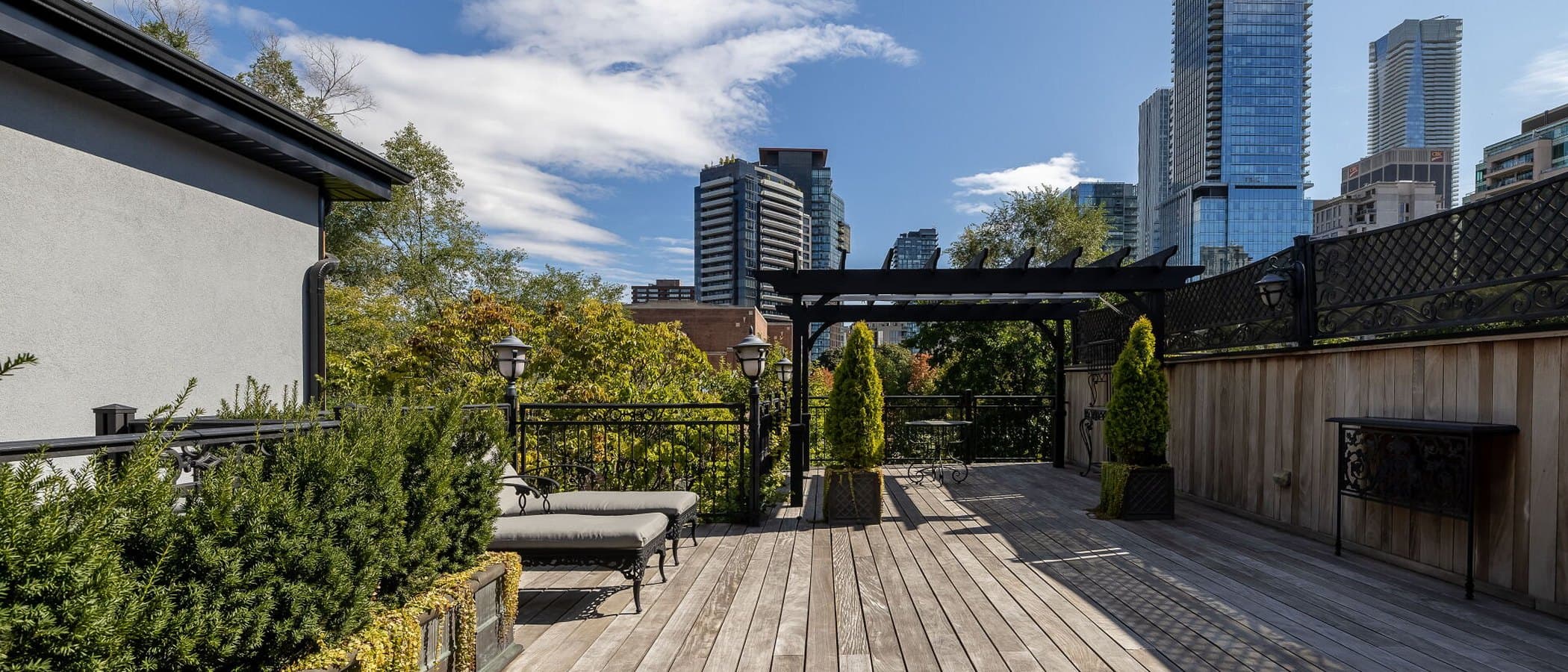 Rooftop terrace with a pergola and the Toronto skyline beyond