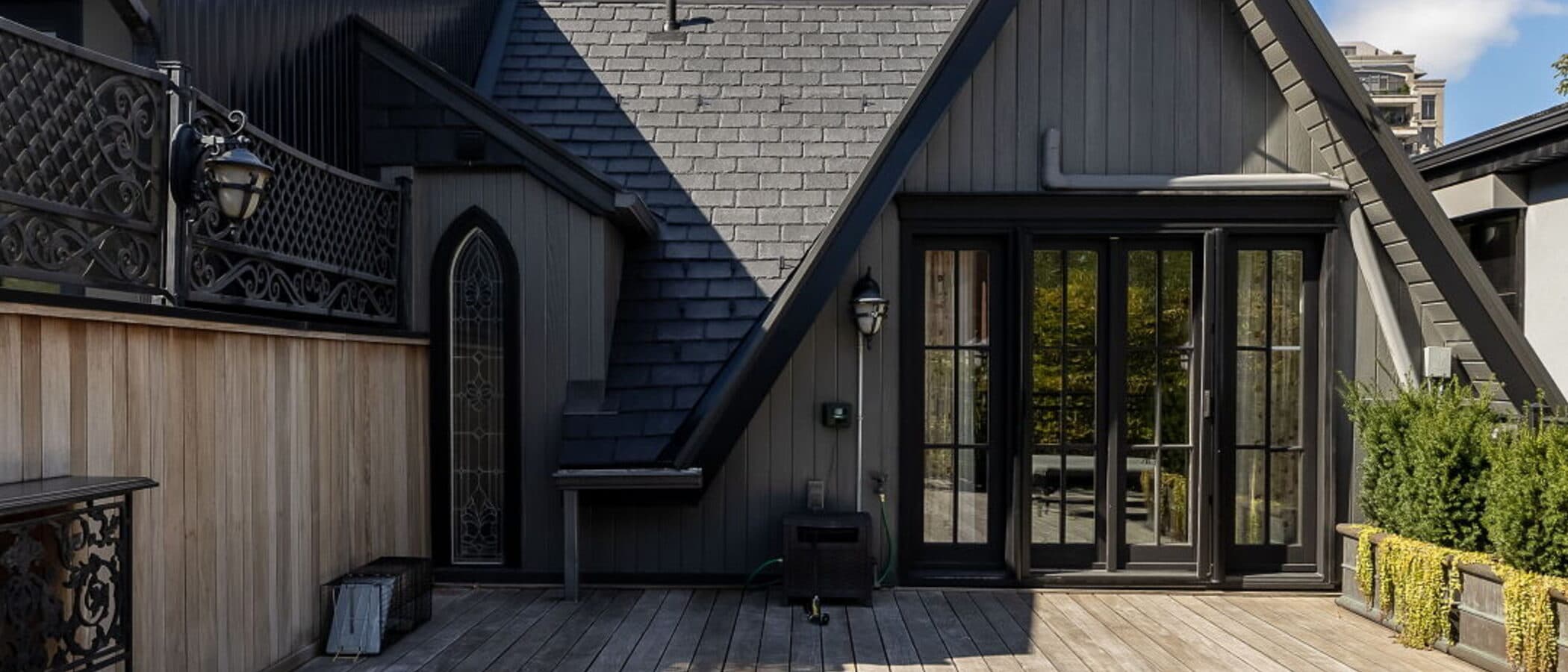 Gothic gable in black slate with a pointed stained glass window