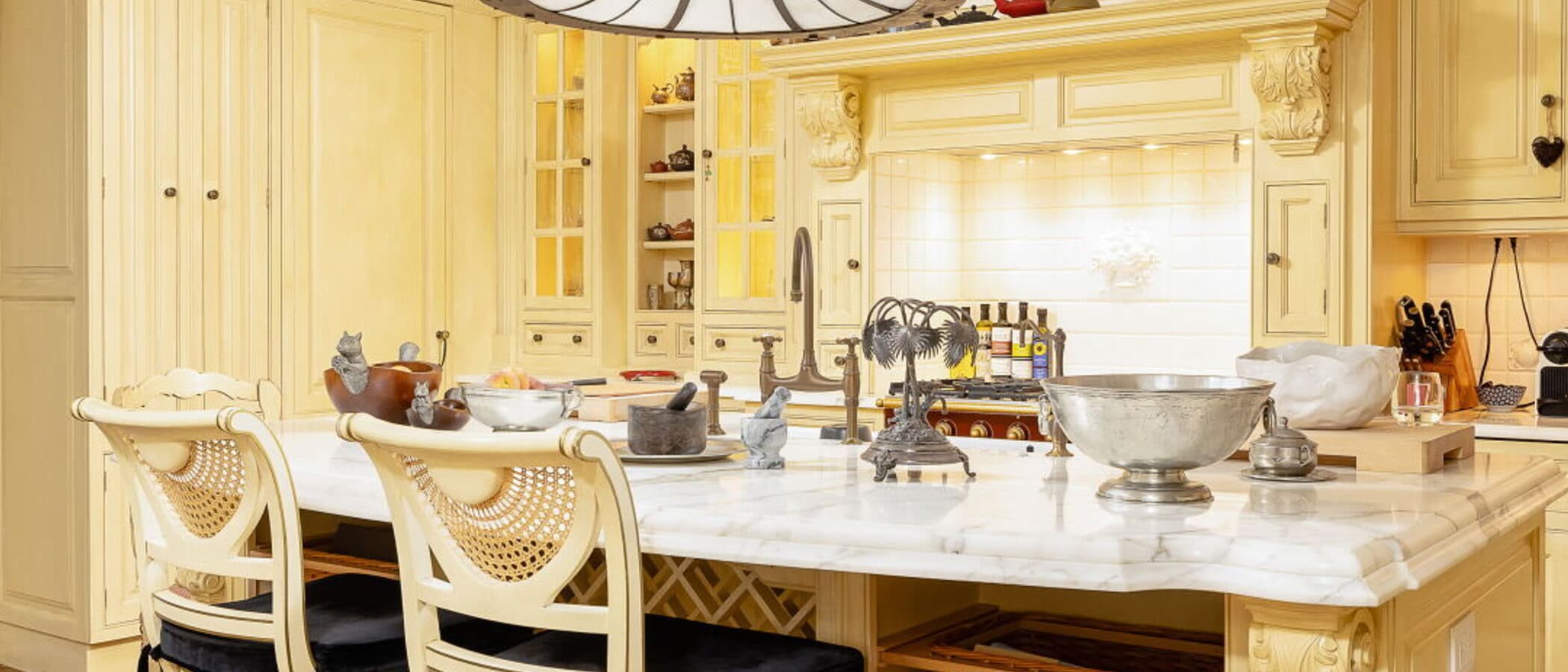 Kitchen island with carved millwork, marble counters and plate racks