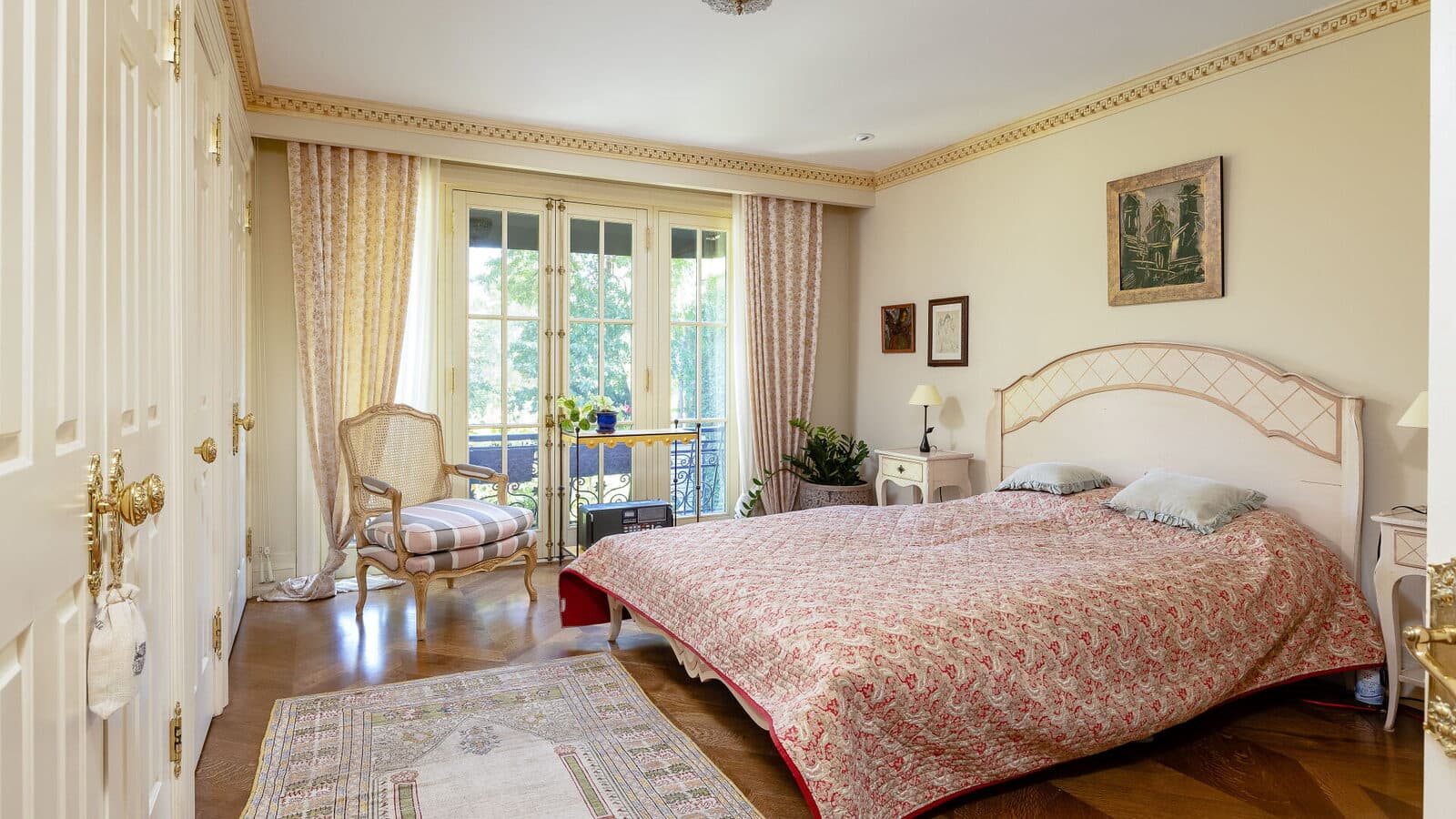 Guest bedroom with French doors opening to an iron balcony