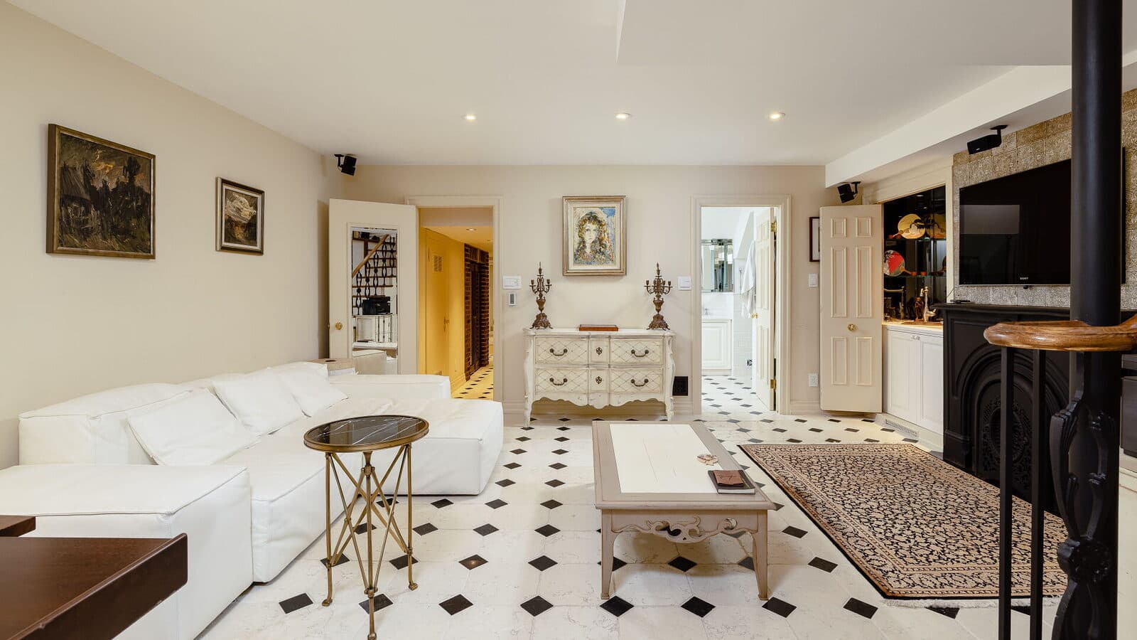 Basement lounge with checkerboard marble floors and a white sectional