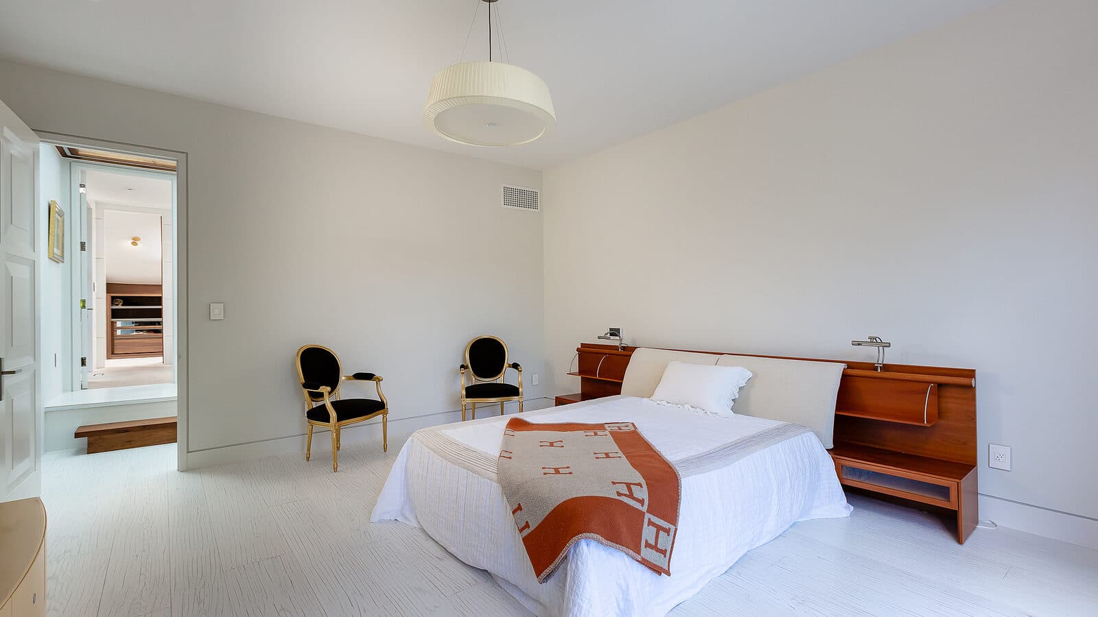 Secondary bedroom with a wood bed frame and an orange accent throw