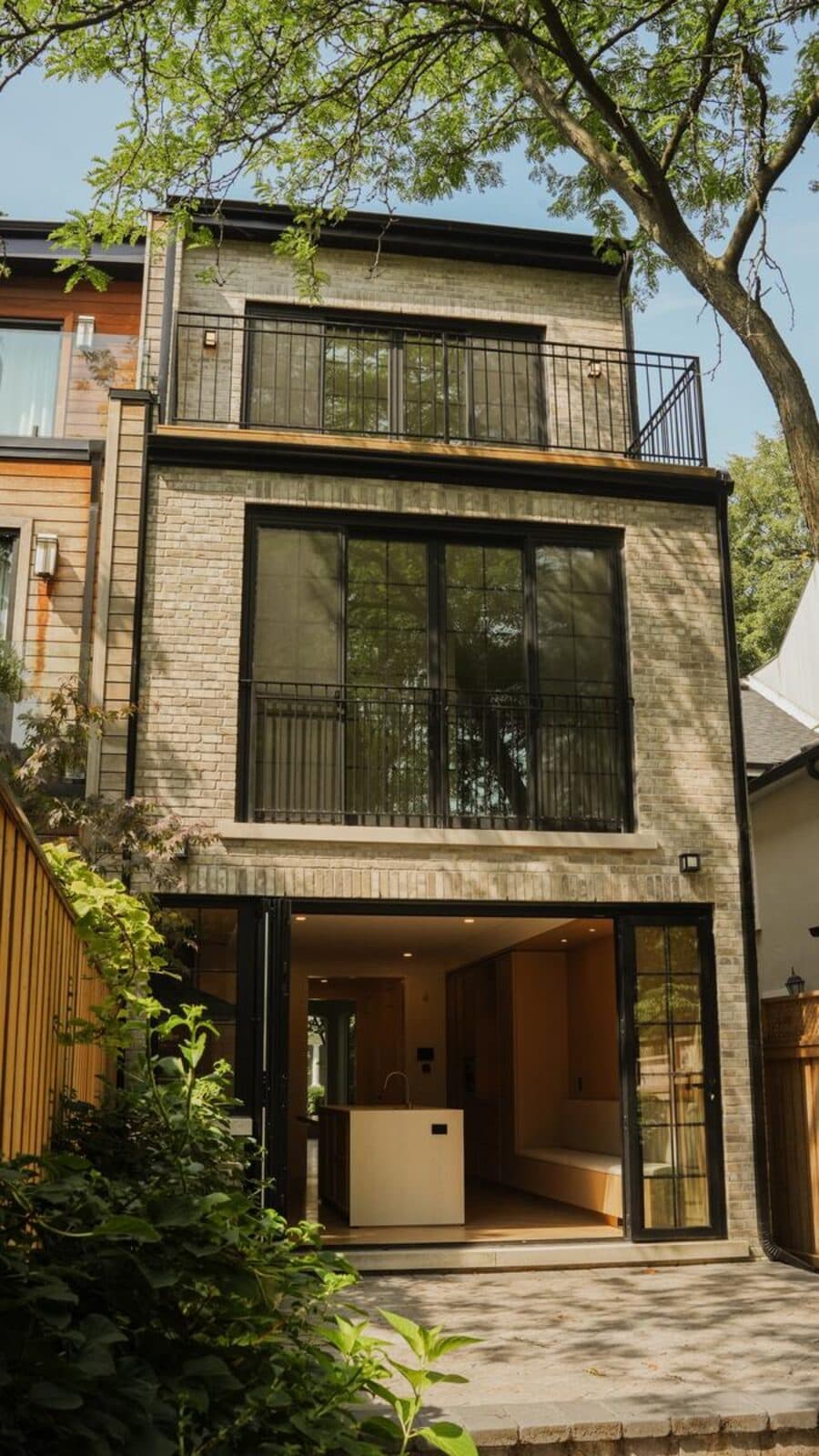 Rear elevation in stacked black steel windows and iron balconies opening to a courtyard