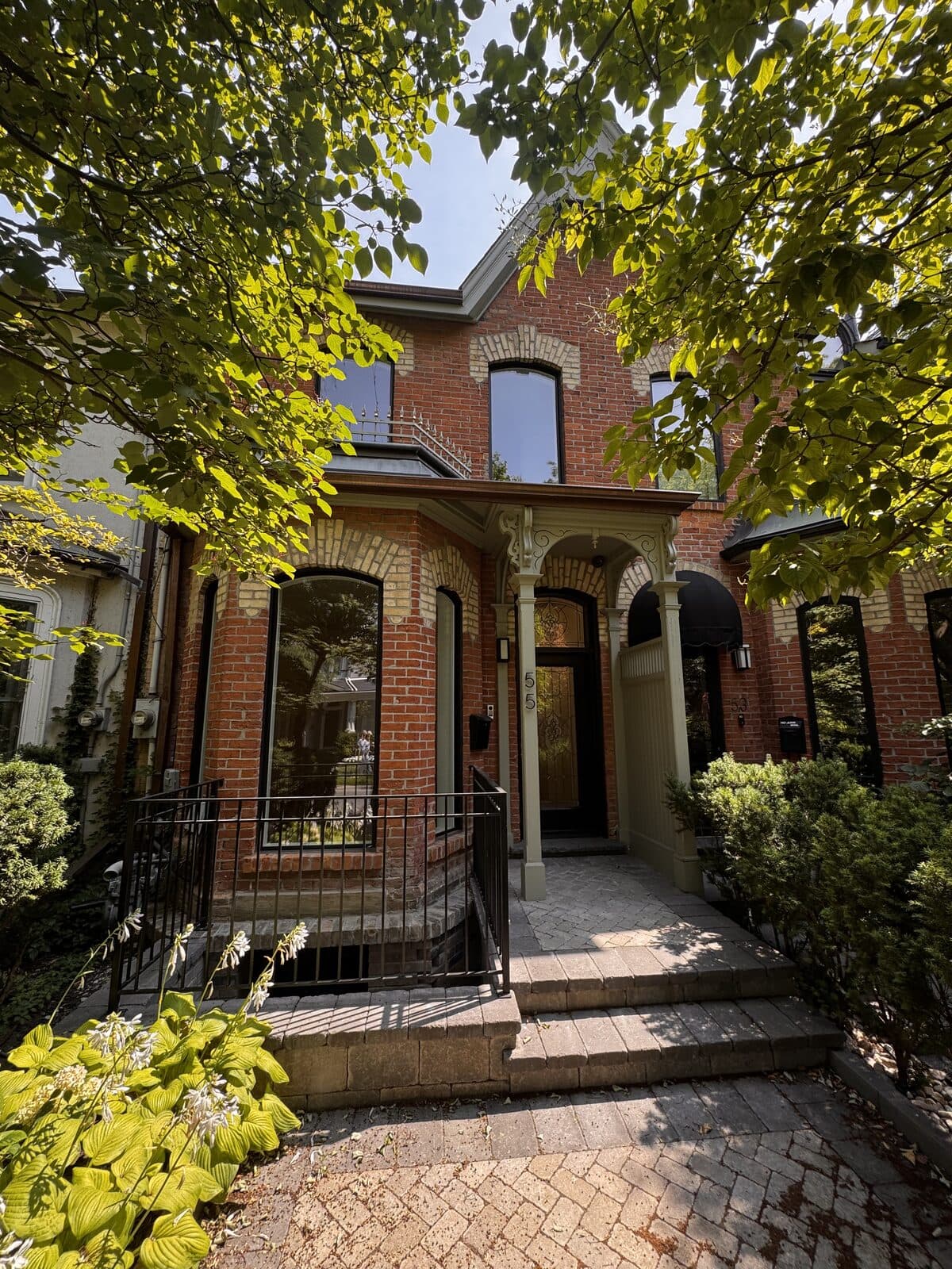 Street level view of the brick facade behind front greenery