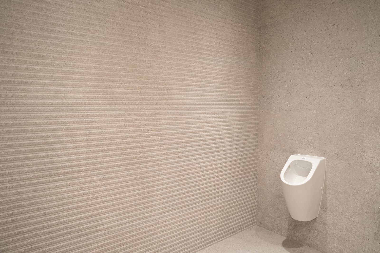 Washroom with a fluted feature tile wall and a wall hung urinal