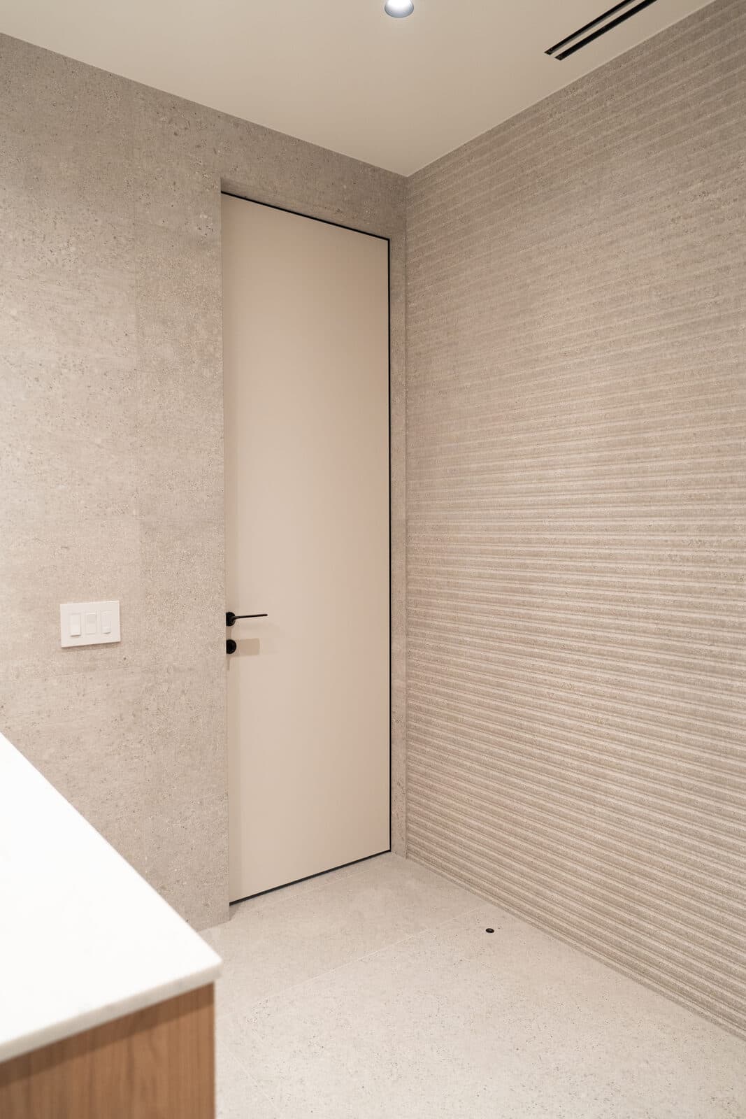 Washroom door set into a fluted tile wall
