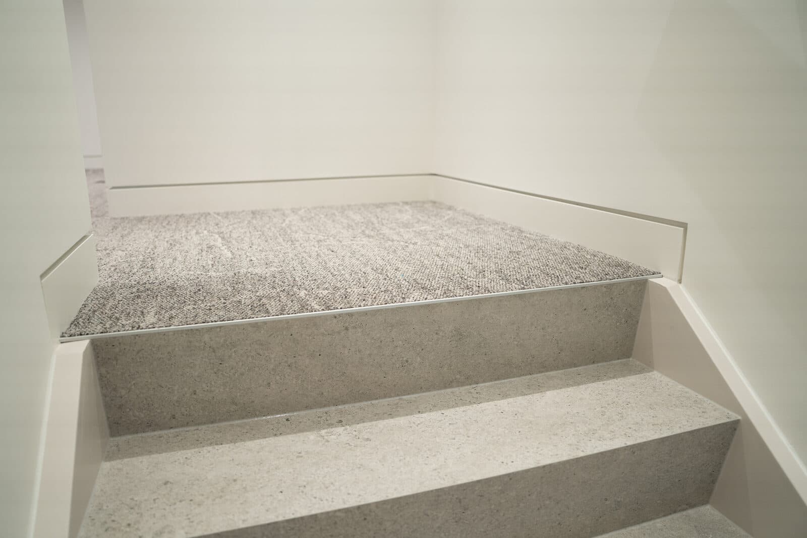 Stair landing detail where carpet meets stone