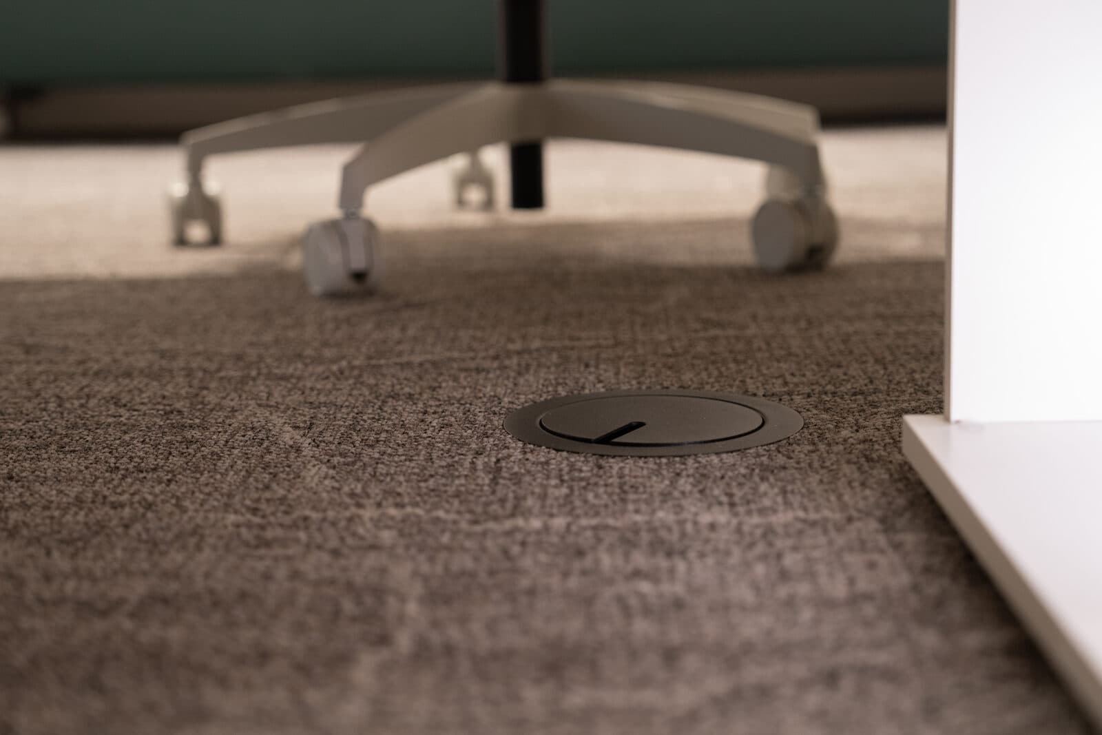 Under desk floor grommet detail in shallow focus