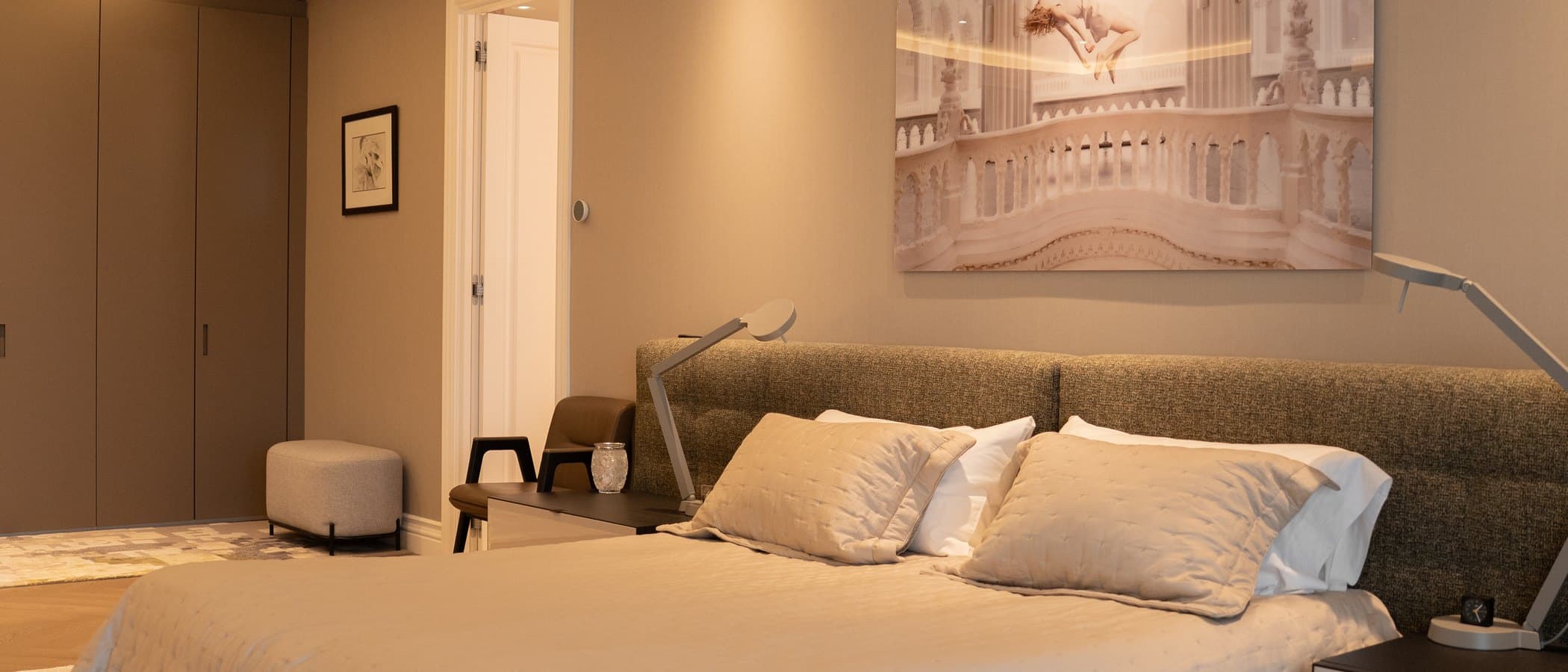 Bedroom finished in soft neutrals with concealed cove lighting