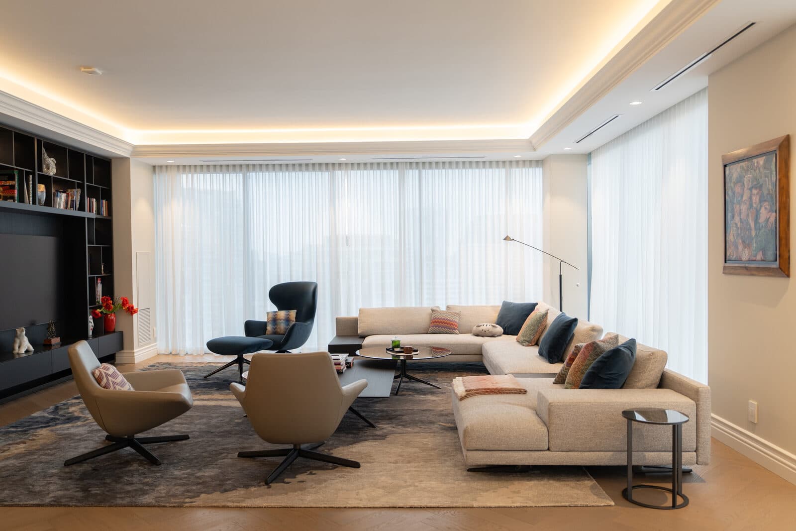 Living room wide with sheer drapery, a pale sectional and layered lighting