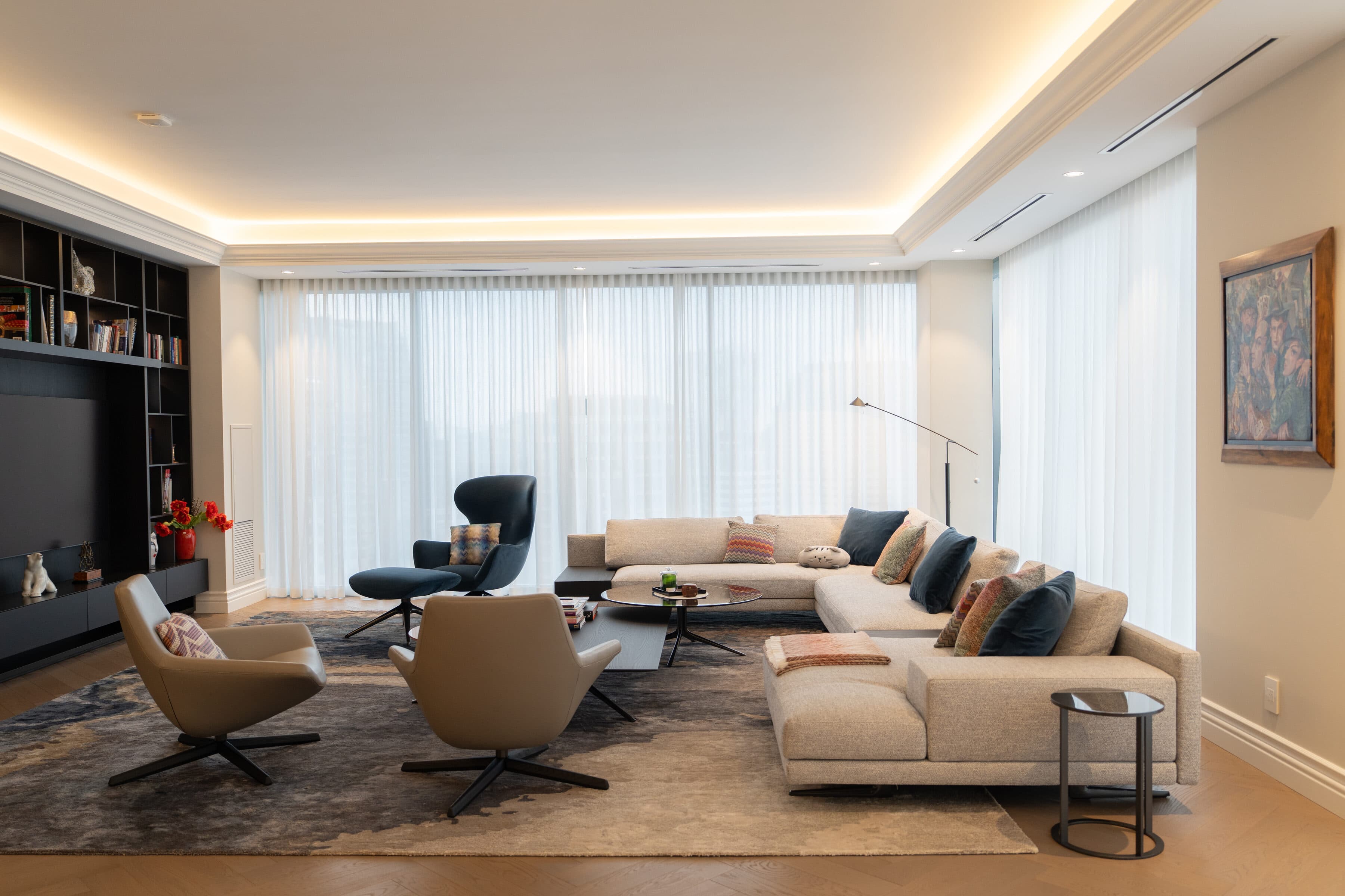 Living room wide with sheer drapery, a pale sectional and layered lighting