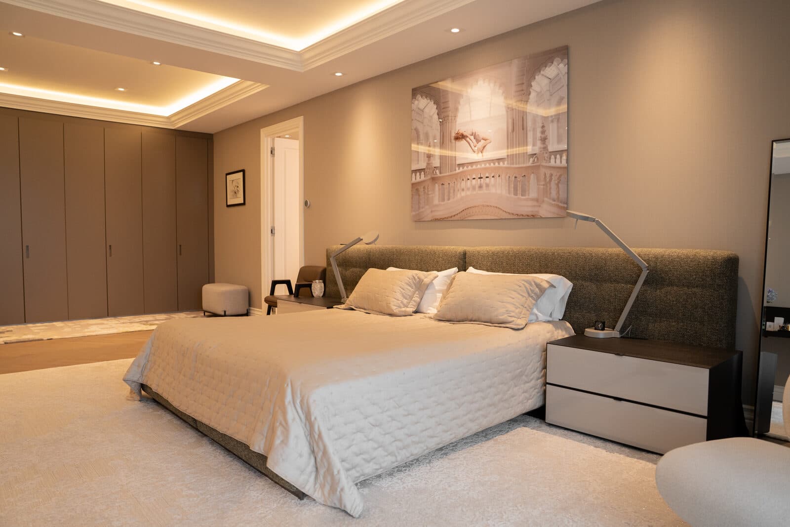 Primary bedroom in warm neutrals with layered drapery
