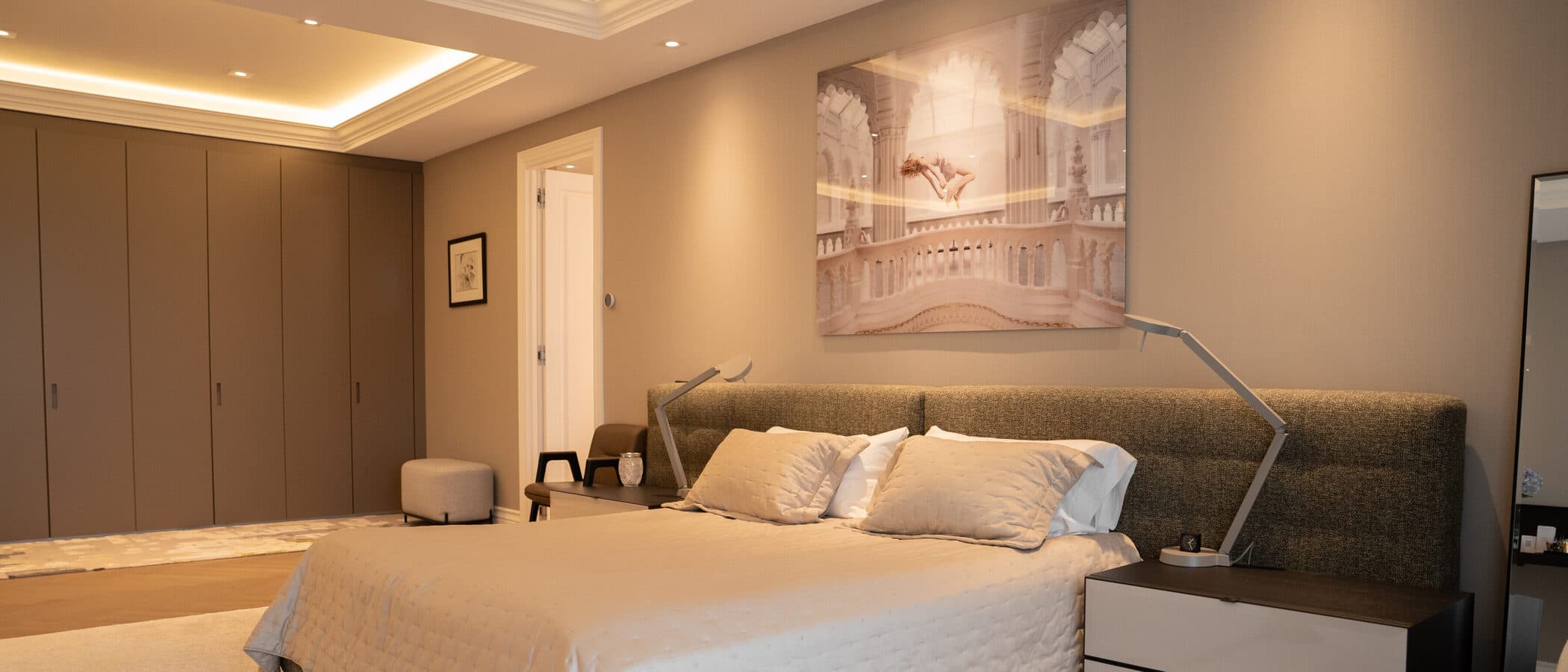 Primary bedroom in warm neutrals with layered drapery