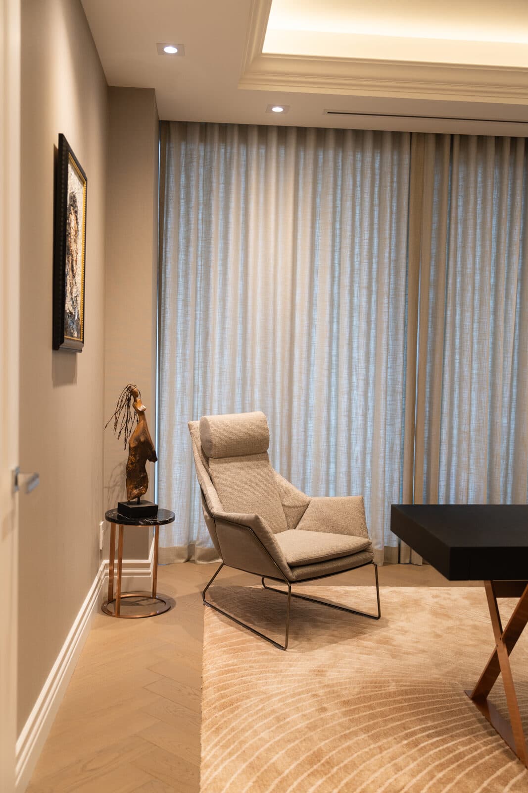 Office corner with an armchair, a bronze sculpture and a clear desk