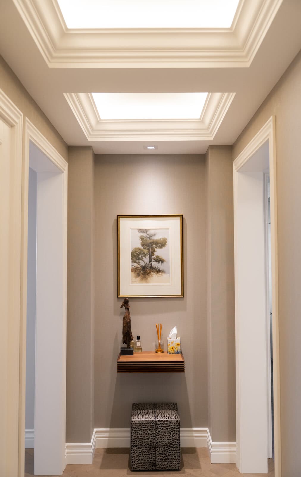 Hallway niche beneath two illuminated coffered light wells