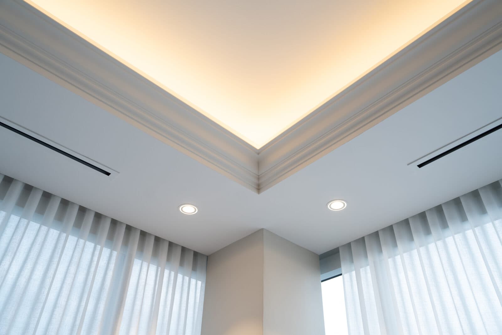 Cove lit ceiling corner above sheer drapery