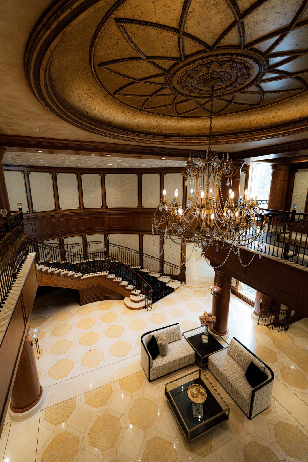 Vertical view from the gilded dome and chandelier down to a seating vignette
