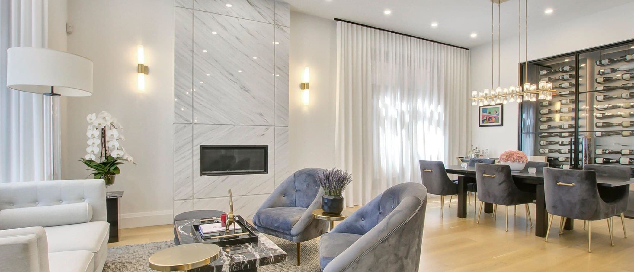Living room with a marble fireplace and a glass enclosed wine display