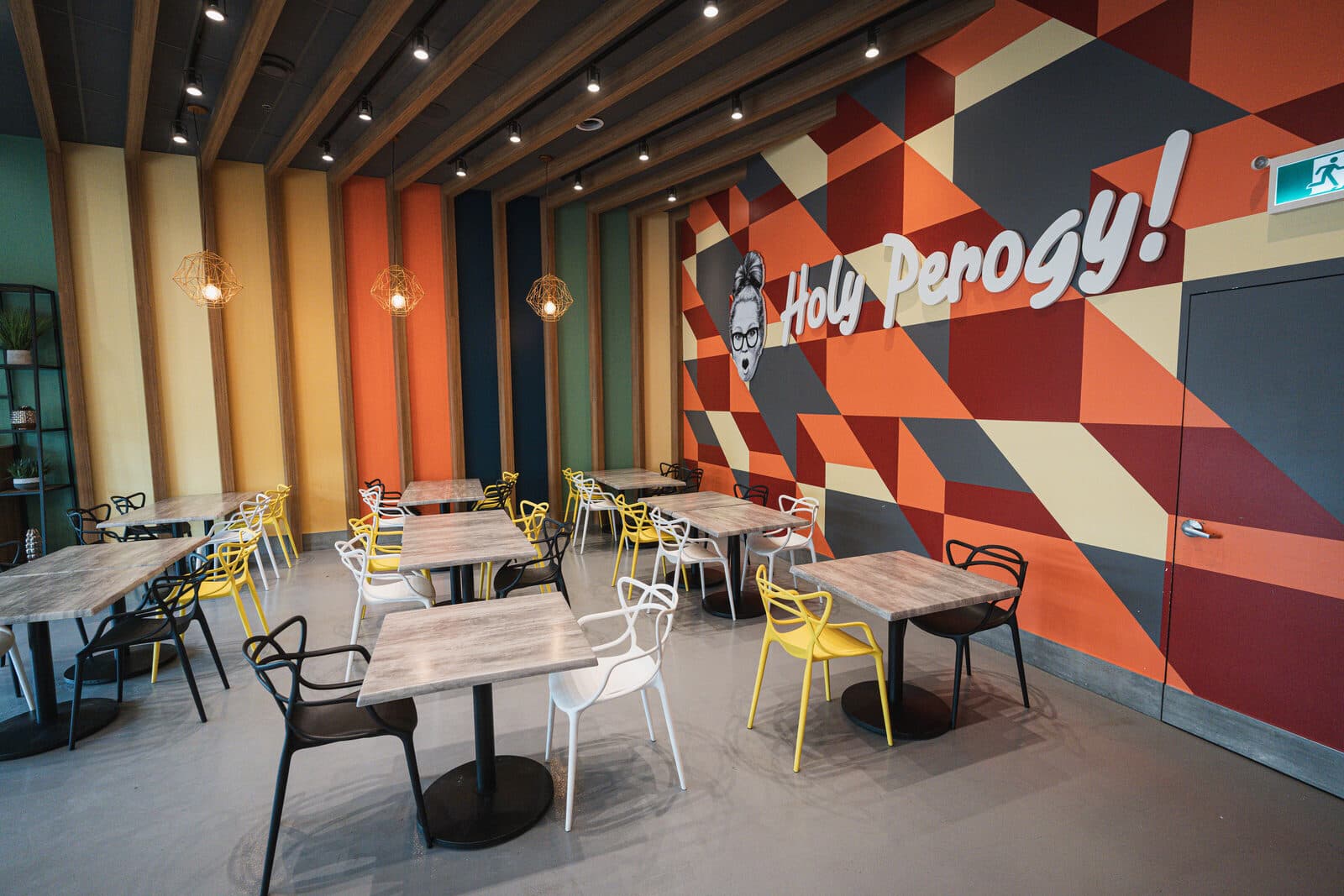 Dining room with a geometric supergraphic wall and timber slat ceiling