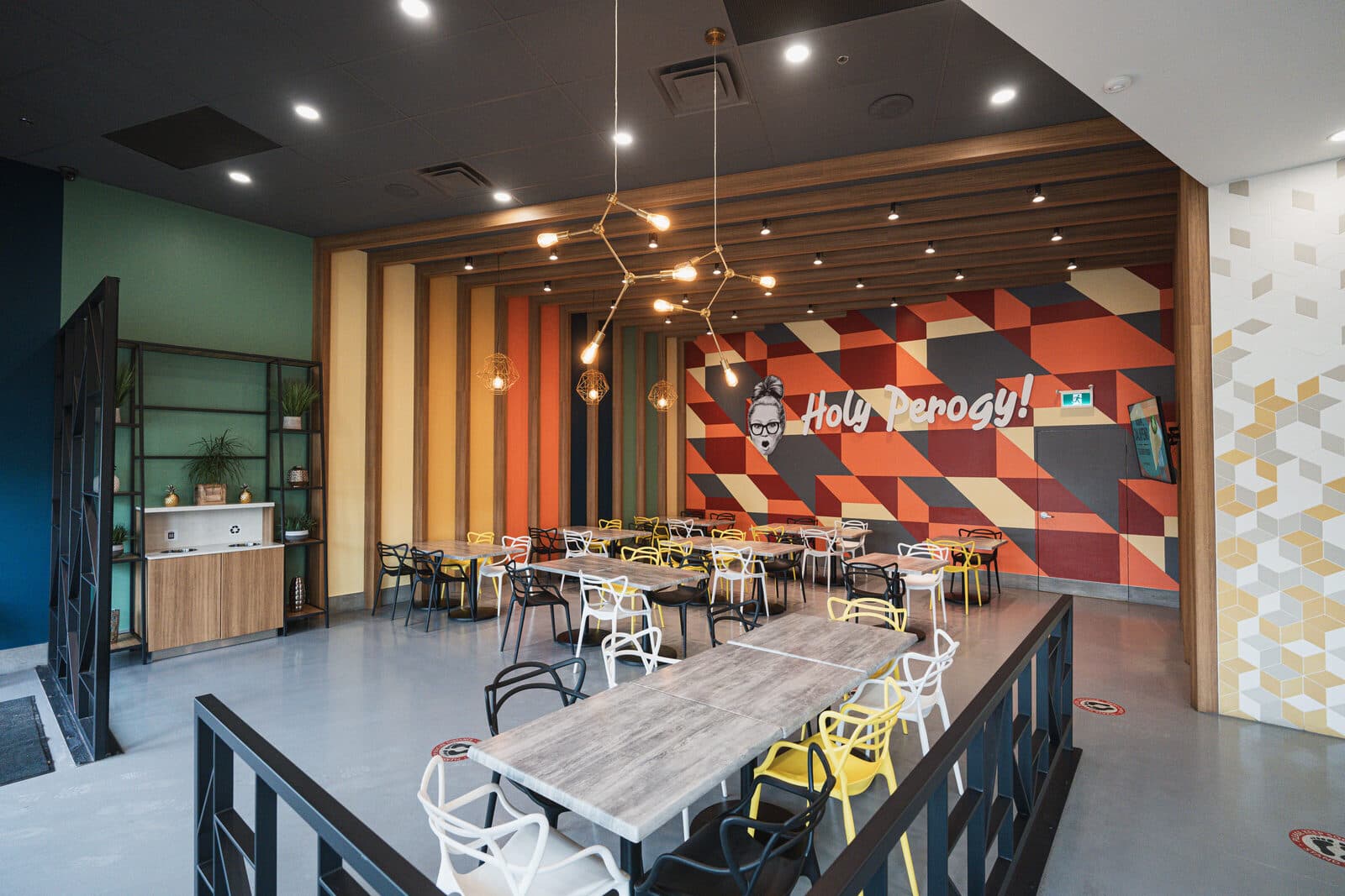 Service counter and dining tables beneath a sculptural branch pendant
