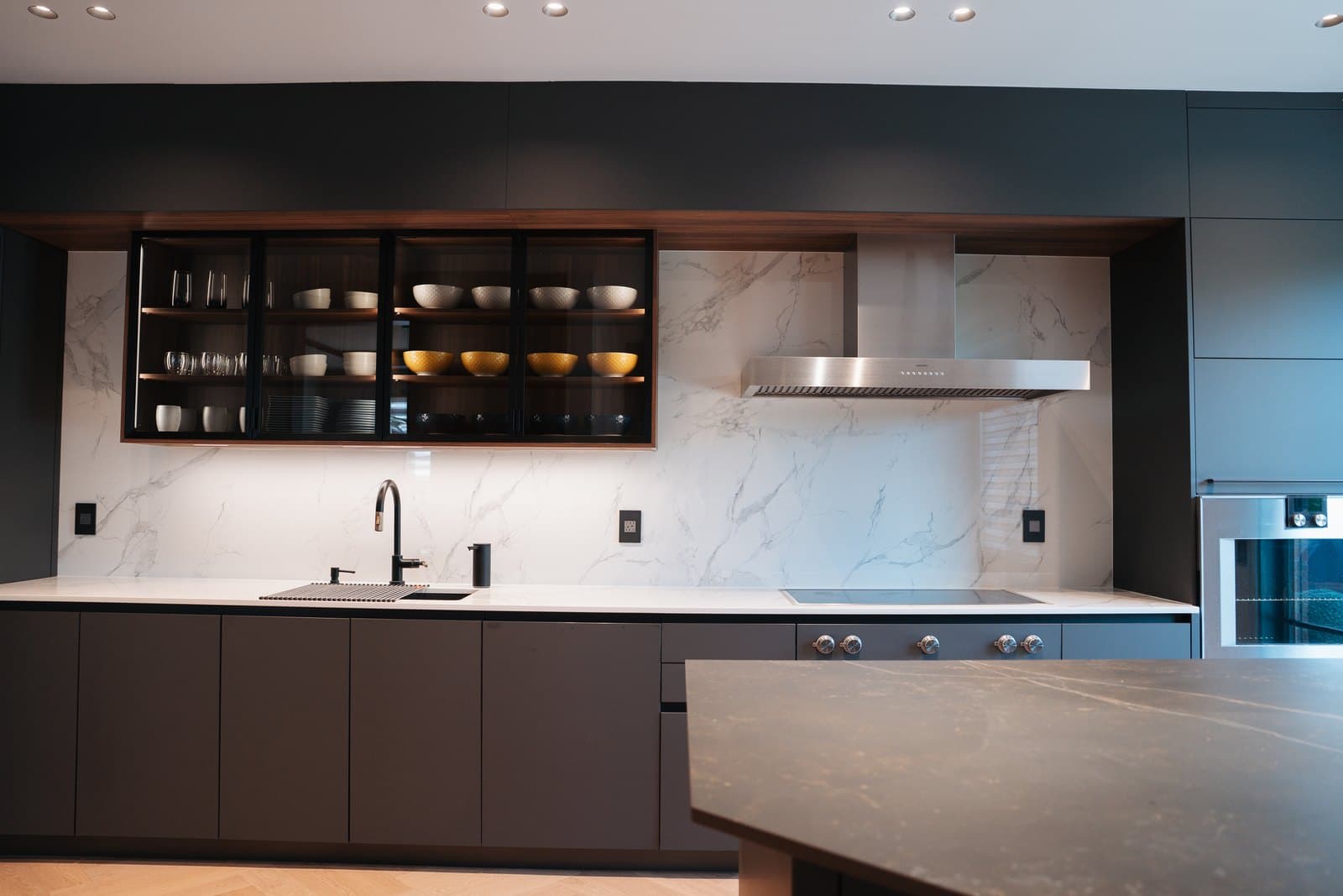 Charcoal kitchen with backlit display shelving and herringbone floors