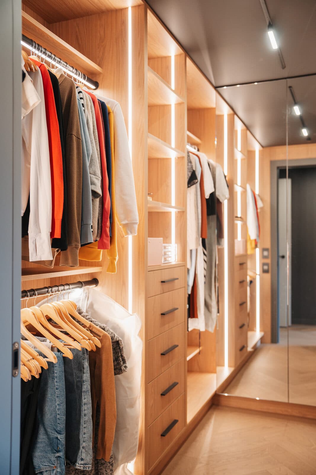 Walk in dressing room in warm oak with backlit display and open hanging