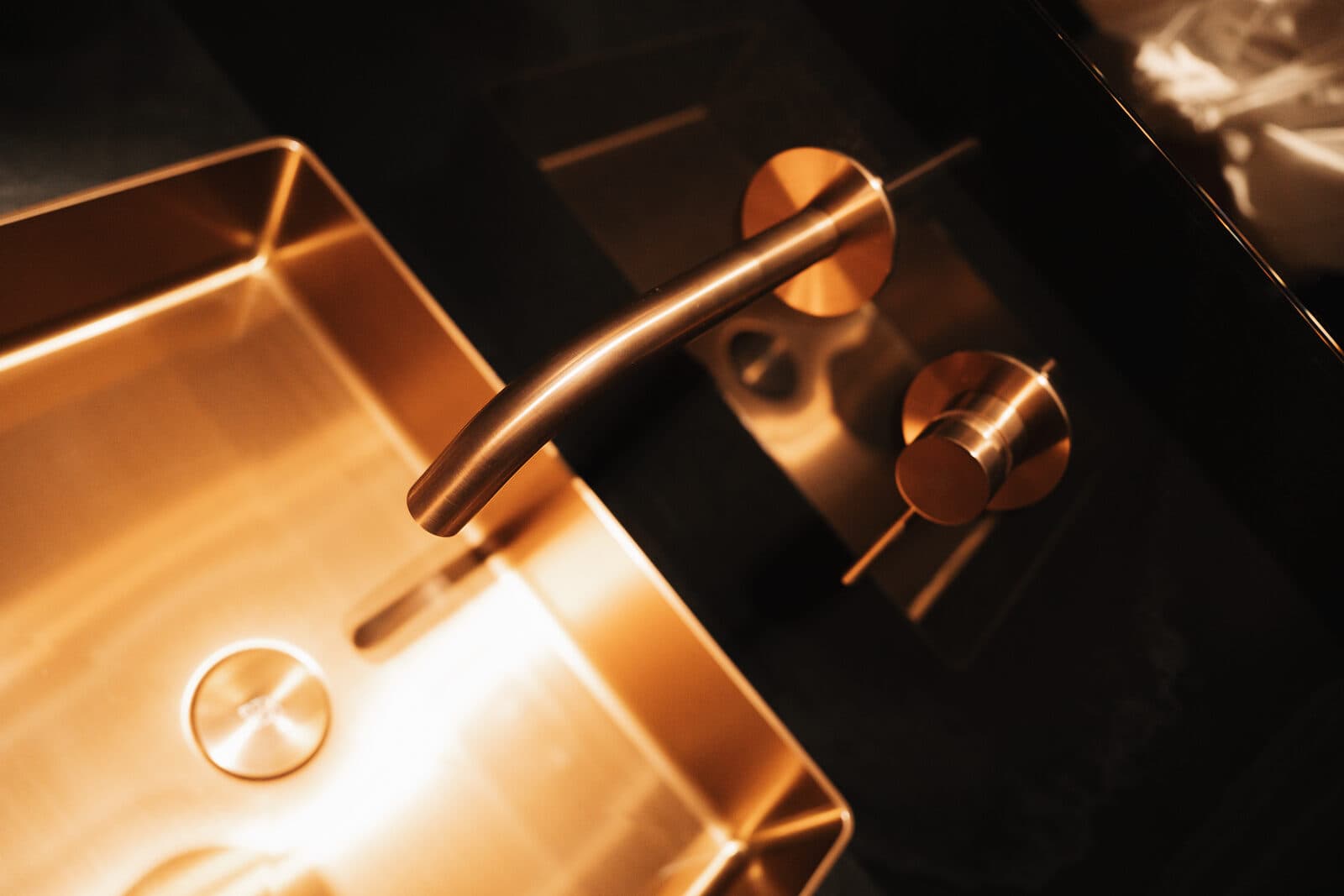 Copper faucet over a vessel sink in a dark powder room