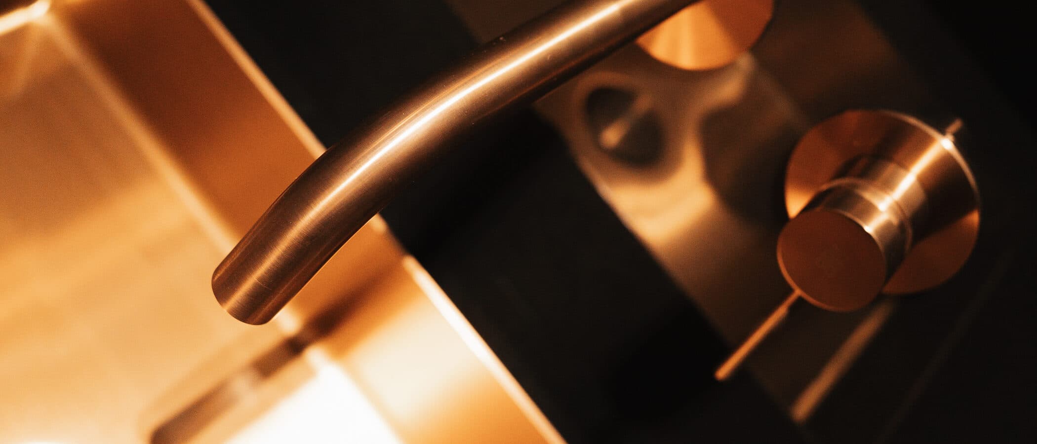 Copper faucet over a vessel sink in a dark powder room