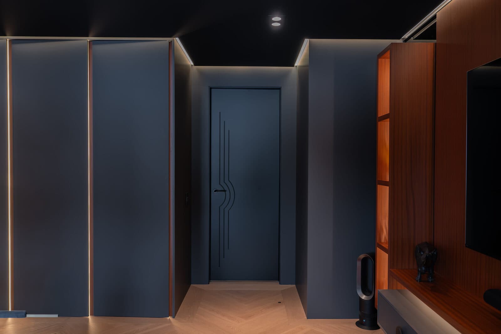 Corridor to the study with an art deco door and warm display lighting