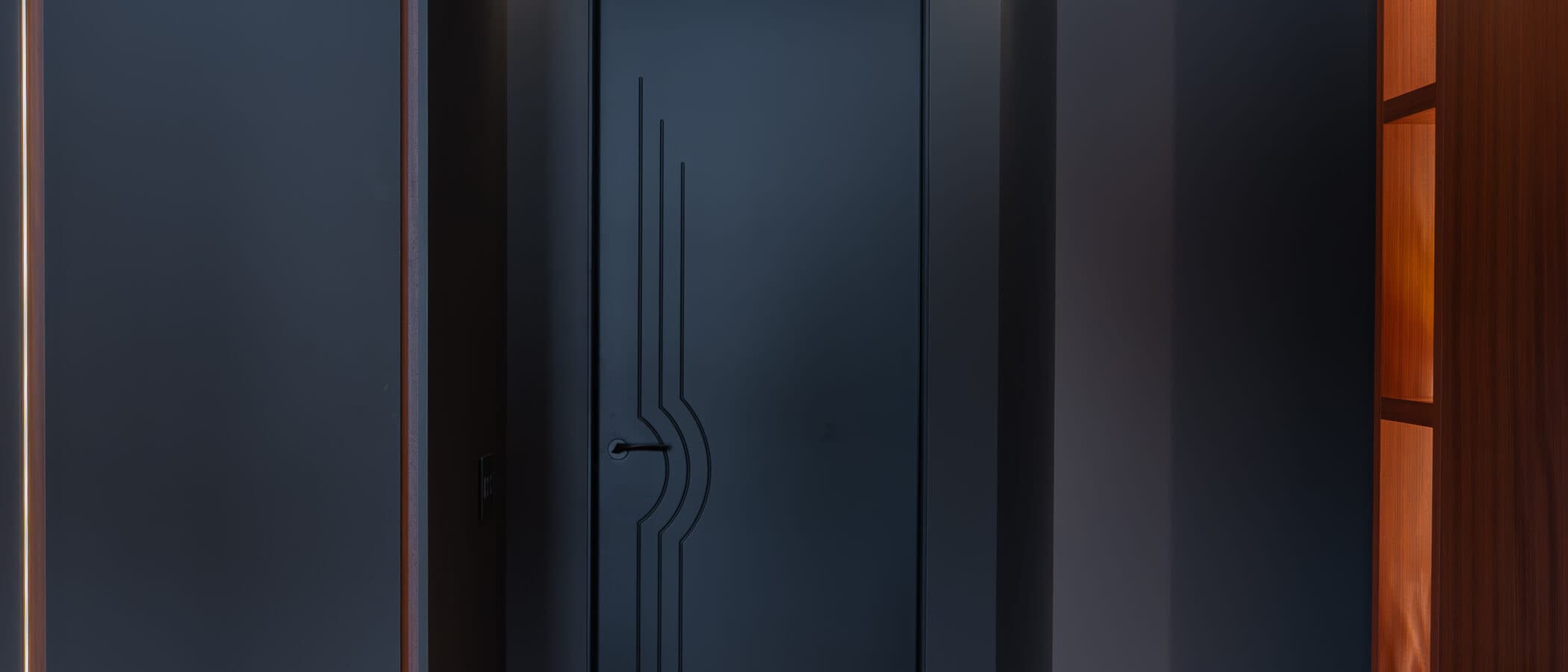 Corridor to the study with an art deco door and warm display lighting