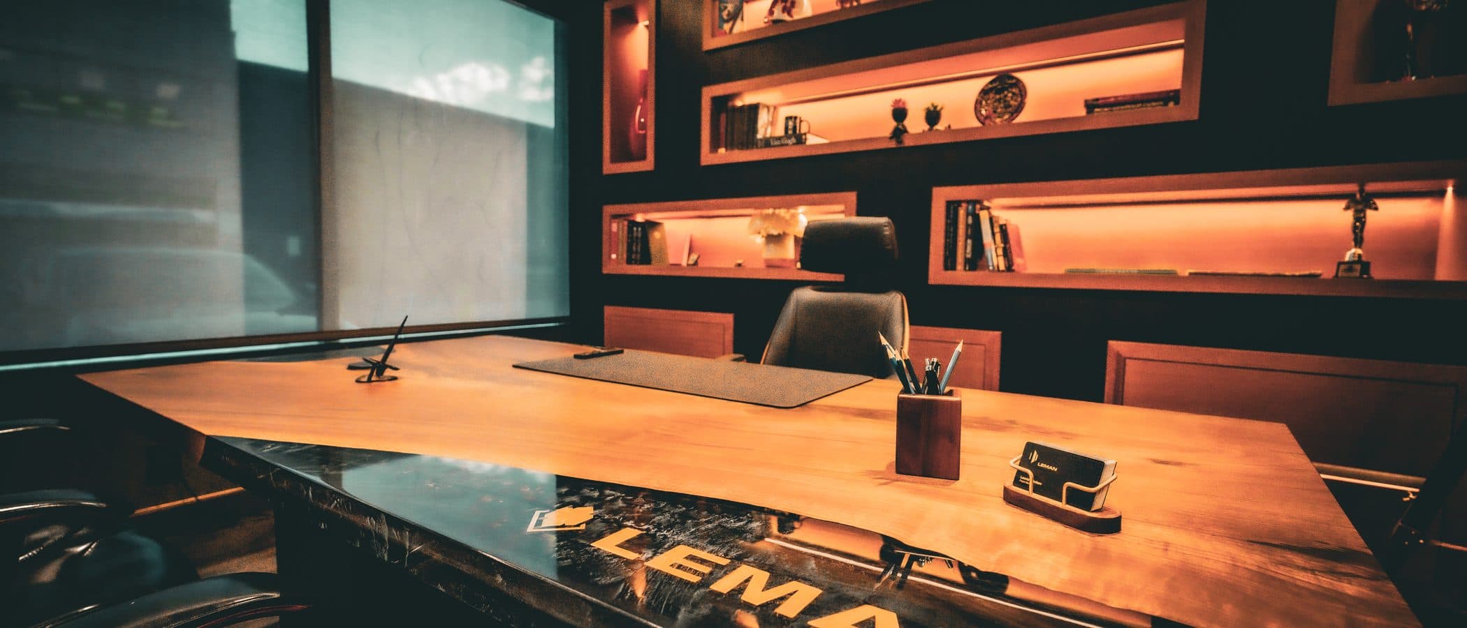 Leman showroom boardroom at 5050 Dufferin Street with a live edge table and brass display walls