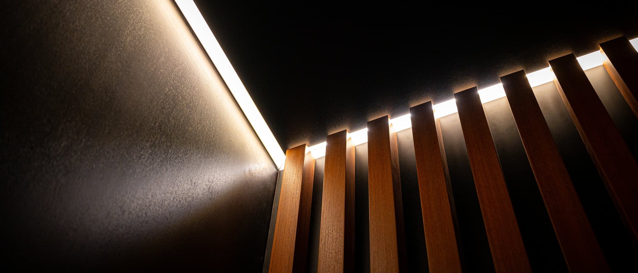 Backlit timber slat wall sweeping through the design studio