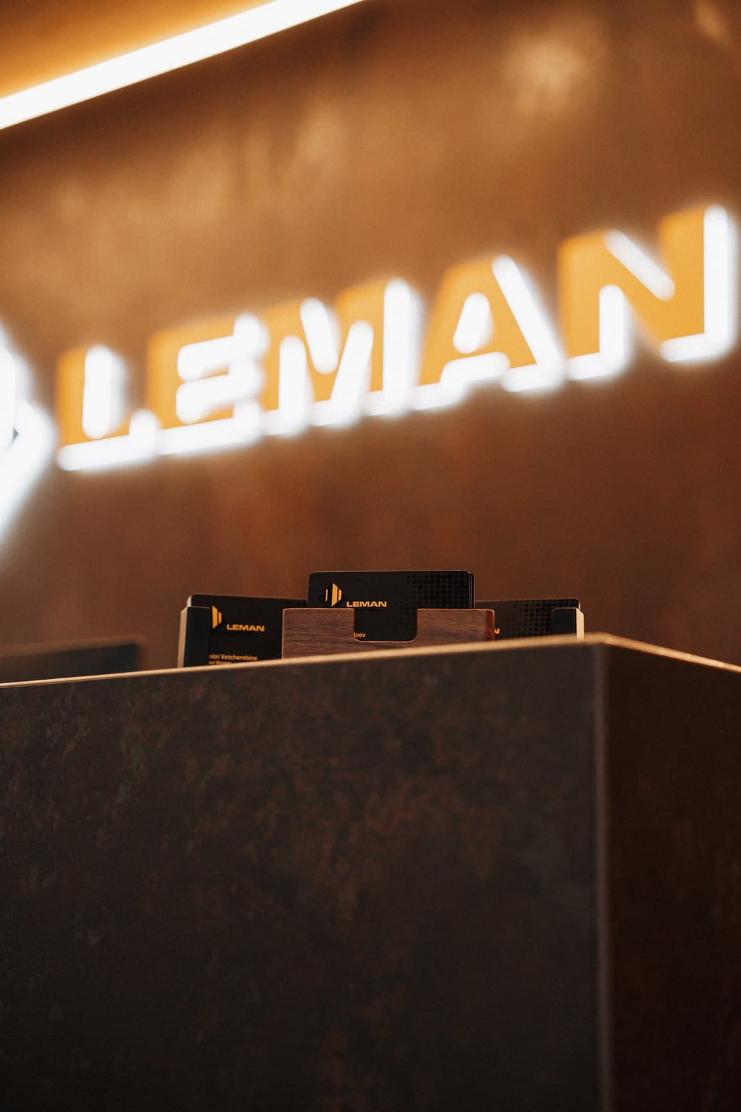 Illuminated studio sign mounted above a bronze reception desk
